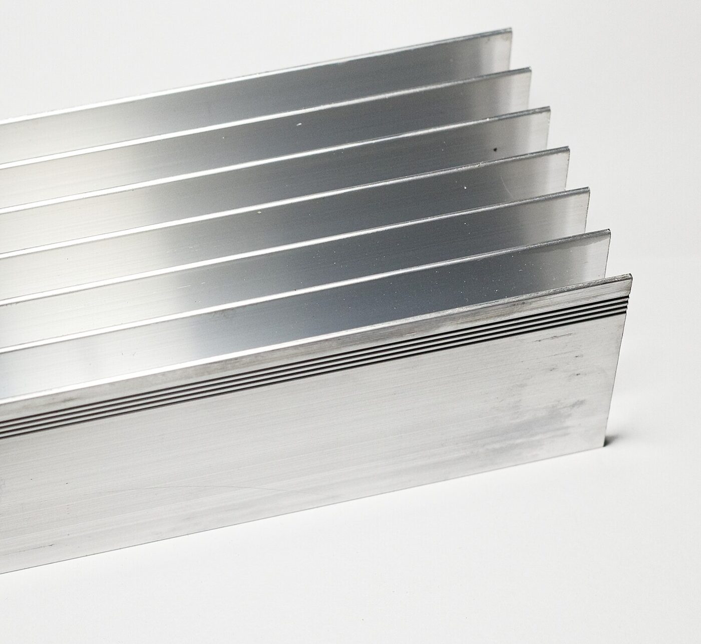 Close-up of a finned aluminum extrusion showing the machined fin edges